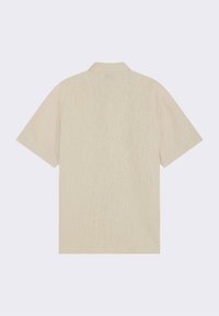 Camisa de manga corta en un color beige claro, con un tejido texturizado y un patrón sutil, que presenta un cuello sencillo y un corte relajado.