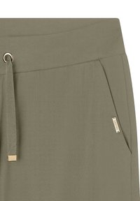Jogging olive en vert fabriqués en tissu doux, avec un cordon de serrage à la taille, dotés de deux poches latérales et d'un petit accent de marque en métal.