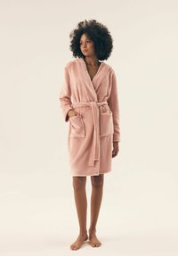Różowy polarowy szlafrok z kapturem, z paskiem w talii i dwiema przednimi kieszeniami; miękka tekstura i długość do połowy uda.