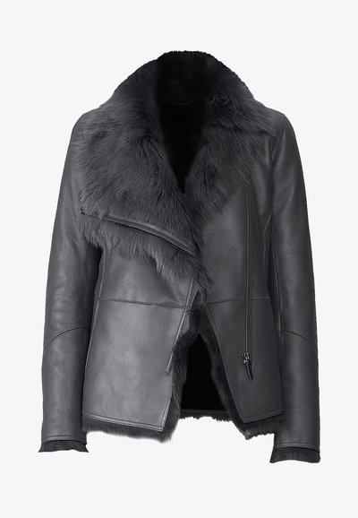 Chaqueta de cuero negra con un cuello de pelo sintético, cremallera delantera asimétrica, acabado texturizado y flecos en el dobladillo y los puños.