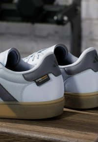 Lichtblauwe sneakers met grijze accenten, gemaakt van duurzaam materiaal. Beschikt over gestructureerde oppervlakken, een Cordura-label en een gumrubberen buitenzool.
