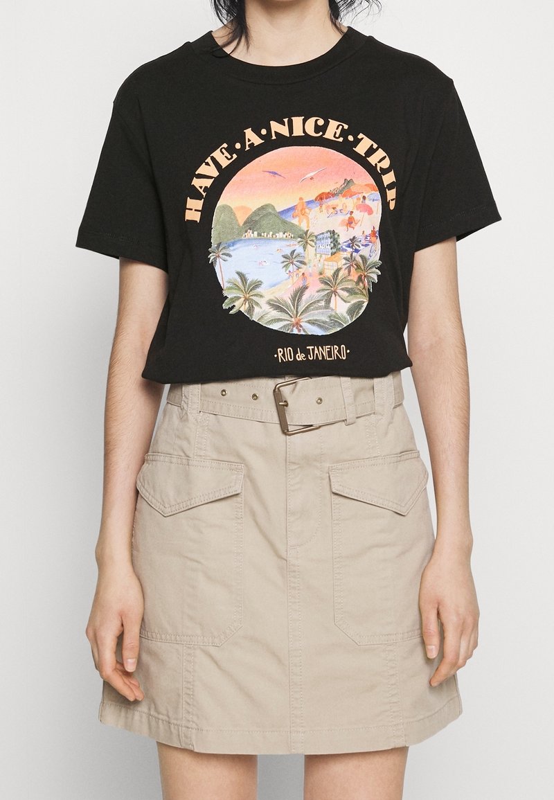 Sort bomuld T-shirt med et farverigt motiv med teksten "HAVE A NICE TRIP" og palmer, kombineret med en beige bomuldsskjørt med lommer.