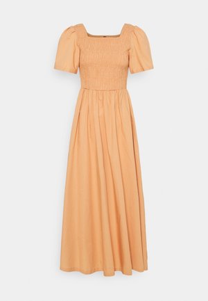 Robe maxi pêche avec encolure carrée smockée et manches courtes bouffantes, jupe fluide, présentée sur fond uni.