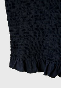 Námořnická modrá smockovaná tkanina s volánkovým lemem. Elastická struktura vytváří nápadné řasení, což dodává materiálu rozměr. Hladký a jemný povrch.