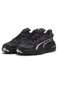 Zwarte hardloopschoenen met een gestructureerd oppervlak, voorzien van een witte zijstreep, gevoerde zolen en Gore-Tex branding voor waterdichtheid.