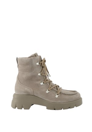 Bottines en daim beige avec un bout rond, un laçage à l'avant, des œillets en métal et une semelle en caoutchouc épaisse. Comprend des détails de couture sur les côtés.