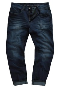 Vaqueros de mezclilla azul oscuro con un corte clásico, que presentan un ligero efecto de desgaste en la parte frontal, bajos doblados y un diseño estándar de cinco bolsillos.