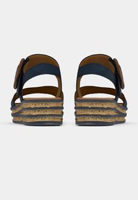Navy blue wedge sandals with a textured cork sole, featuring two wide straps and a decorative buckle accent on the side.