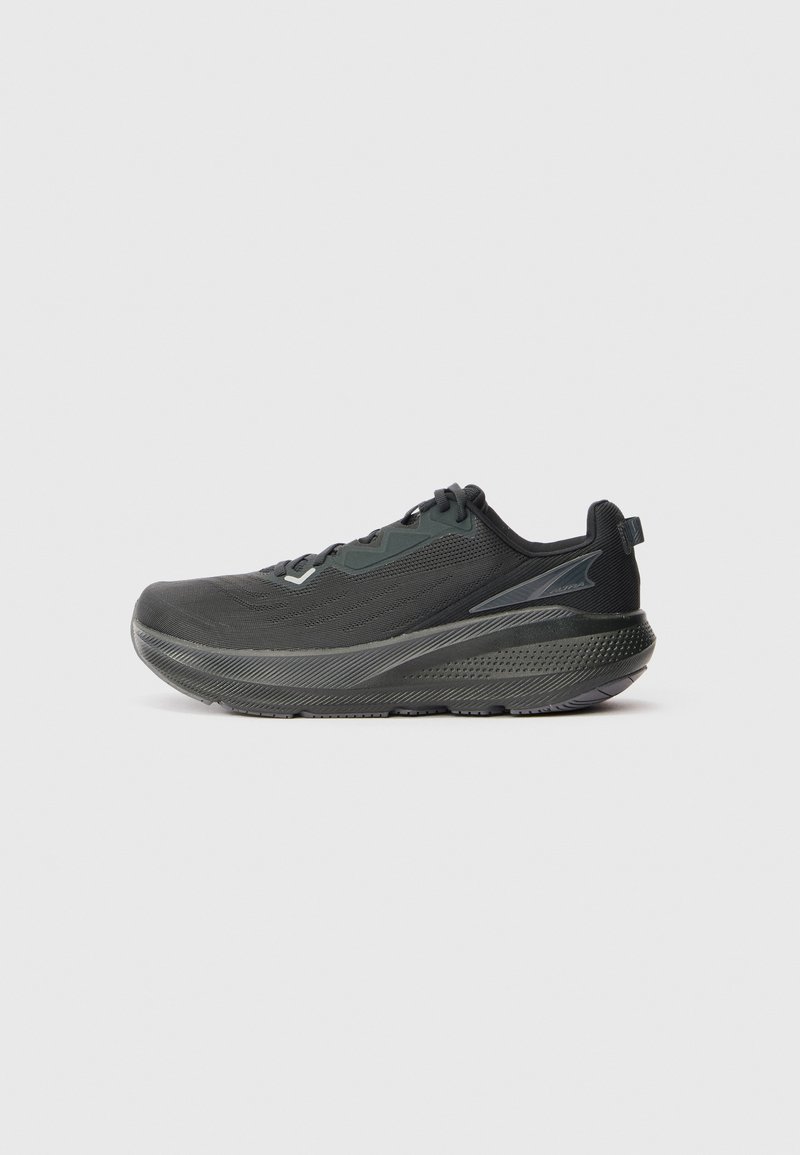 Chaussure de sport noire avec une tige en mesh respirant, une semelle texturée et un design de semelle intermédiaire offrant un bon soutien. Des accents réfléchissants sont présents.