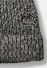 Sweter szary beanie o prążkowanej fakturze i złożonym mankiecie, z haftowanym na czarno logo drzewa z przodu.