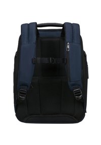 Zaino blu scuro con schienale imbottito in rete, spallacci regolabili, cinturino da petto e tasca con zip su uno spallaccio.