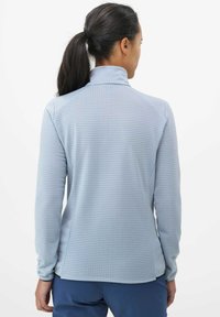 Pull-over à manches longues bleu clair avec col haut, en tissu texturé à motif quadrillé, et coupe décontractée.