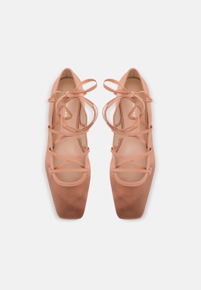 Bailarinas rosa claro con un acabado de ante suave, puntera cuadrada y detalles de cintas cruzadas en la parte superior. Diseño de suela plana.