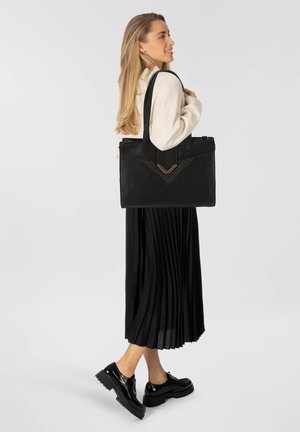Borsa tote in pelle nera con finitura texturizzata, dotata di hardware dorato e un design a chevron con borchie sul davanti. Manici doppi robusti.