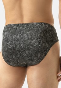 Costumi da bagno neri attillati con motivo paisley grigio, caratterizzati da una texture liscia e una vestibilità aderente, adatti per nuotare o rilassarsi.