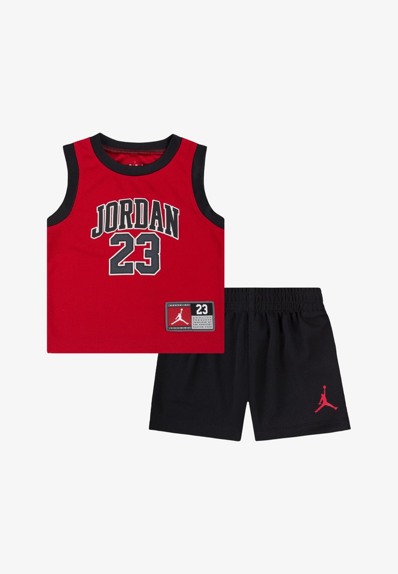 Sarkans tīkls sporta krekls ar uzrakstu "JORDAN 23" melniem treknraksta burtiem, kombineēts ar melnām šortām ar sarkanu Jumpman logotipu. Viegls sporta apģērbs.