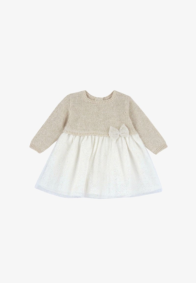 Haut beige en tricot à manches longues ; jupe blanche à pois dorés ; caractérisé par un nœud décoratif à la taille. Texture douce, encolure ronde.