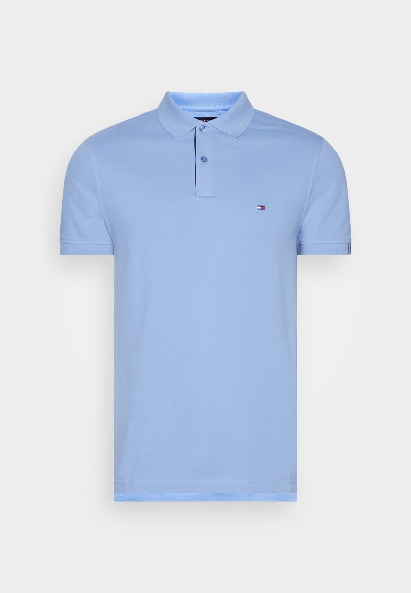 Polo bleu clair à manches courtes avec col, deux boutons et un petit logo rectangulaire sur la poitrine gauche.