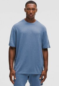 Blå kortærmet t-shirt lavet af blødt stof, med en rund halsudskæring og afslappet pasform, parret med matchende blå shorts.