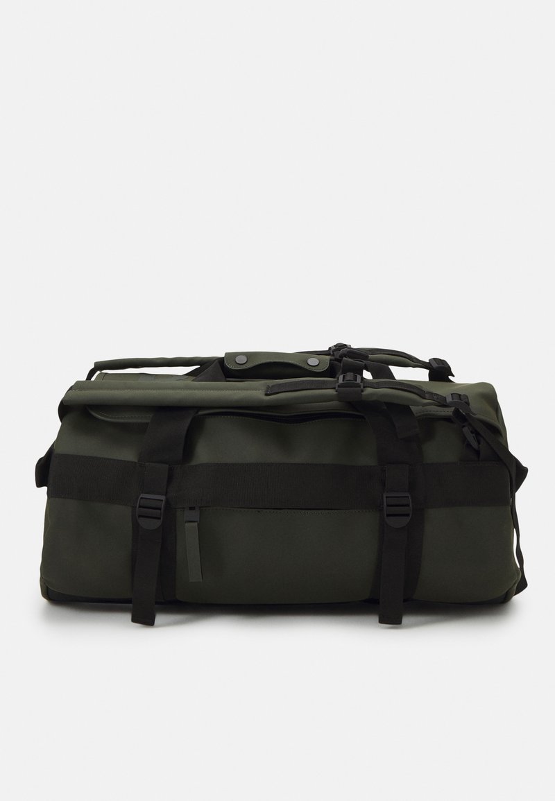 Grønn duffelbag laget av slitesterkt materiale, med justerbare stropper, en glidelåslomme og en sikker klafflås med trykknapper.