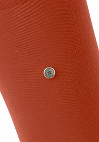 Skórzany skarpet z terakoty o teksturowanej tkaninie, żebrowanym wzorze i małej okrągłej srebrnej odznace z detalem logo.