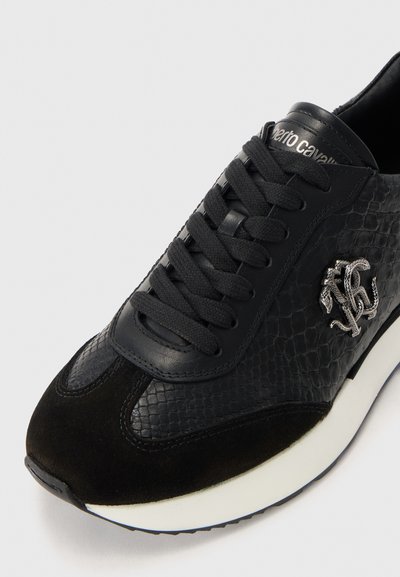 Musthave mustrilineaarne mustad tossud, suledest ninaga, paksu valge tallaga, mustade paeltega ja küljes hõbedane dekoratiivne logo.