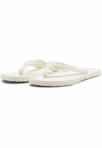 Infradito bianchi con cinturini in tessuto testurizzato, una suola piatta e un design semplice. I cinturini sono annodati alla base per un tocco di dettaglio in più.