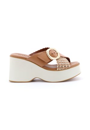 Sandalo con zeppa piattaforma color cuoio, suola bianca, cinturino intrecciato e grande fibbia color oro pallido sulla parte superiore.