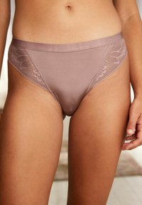 Licht mauve bikini-stijl ondergoed gemaakt van een gladde stof met bloemige kantaccenten aan de zijkanten en een zachte, elastische tailleband.