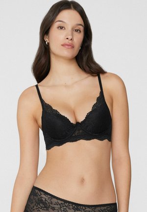 Soutien-gorge en dentelle noire avec bretelles réglables, bord festonné et motif floral, armatures pour un bon maintien et matériau doux et texturé.
