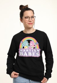 Černá mikina s barevným grafickým vzorem dvou kreslených medvědů, textem "MARTIAN BABES" a duhovým pozadím. Bavlněný materiál, volný střih.
