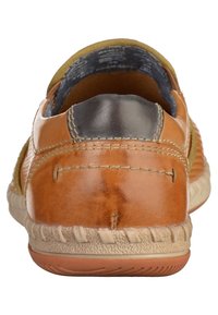 Chaussure en cuir marron avec une surface texturée, talon arrondi et une pièce noire contrastante à l'arrière. Coutures blanches et semelle en caoutchouc visibles.