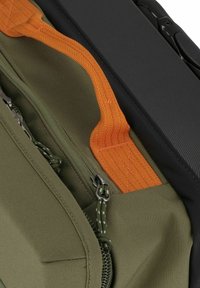Olive green fabric with an orange zipper and stitching, alongside a textured black material. Features zippers and contrasting strap detail.