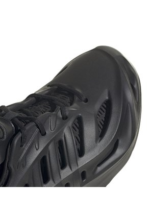 Baskets futuristes noires avec un design sculpté à grille ouverte, semelle épaisse, fermeture à lacets et col de cheville rembourré, vues de profil.