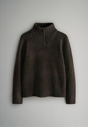 Hnědý pletený svetr na zip s dlouhými rukávy, texturovanou tkaninou a ribovanými manžetami. Má límec ve tvaru stojáčku a jemné variace vzoru.