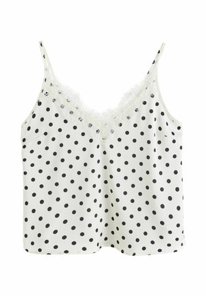 Biały top na ramiączkach z czarnymi grochami, cienkimi ramiączkami i koronkową lamówką wokół dekoltu w kształcie litery V.
