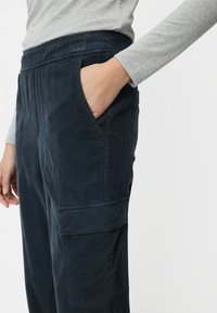 Marineblaue Cord-Cargohose mit elastischem Bund, Seitentasche und markanter vertikaler Rippstruktur; zeichnet sich durch ein locker sitzendes Design aus.