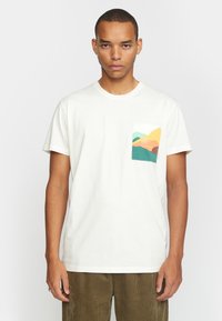 Witte katoenen T-shirt met een kleurrijke bergafbeelding op de linker borstzak. Korte mouwen, ronde hals, ontspannen pasvorm.