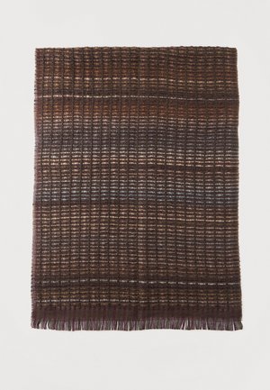 Textil tejido marrón con un patrón de cuadrícula de líneas horizontales y verticales, con sutiles variaciones de color y bordes con flecos en la parte inferior.