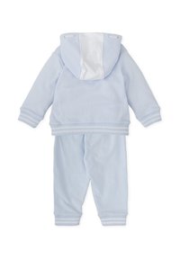 Conjunto de dos piezas en azul claro que incluye una chaqueta con capucha y cremallera, y pantalones a juego, confeccionados en una tela suave con acentos en blanco y puños acanalados.