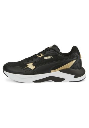 Czarno-złoty sneaker Puma z siateczkową i skórzaną cholewką, białą i czarną podeszwą, sznurowanym zapięciem oraz logo Puma na boku i języku.