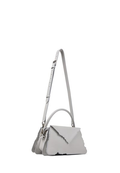 Petit sac à main en cuir gris avec des bords ondulés, une poignée supérieure et une bandoulière réglable, présenté sur un fond blanc.