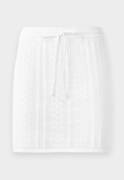 Knit white skirt with a textured pattern and vertical stripes; features a drawstring waist and a scalloped hem.