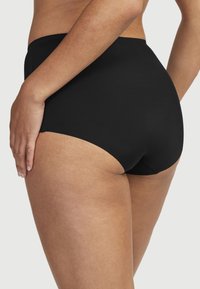 Svart högmidjad trosor med en mjuk textur, med en enkel design. Tyget är stretchigt och passar snuggt runt midjan och låren.