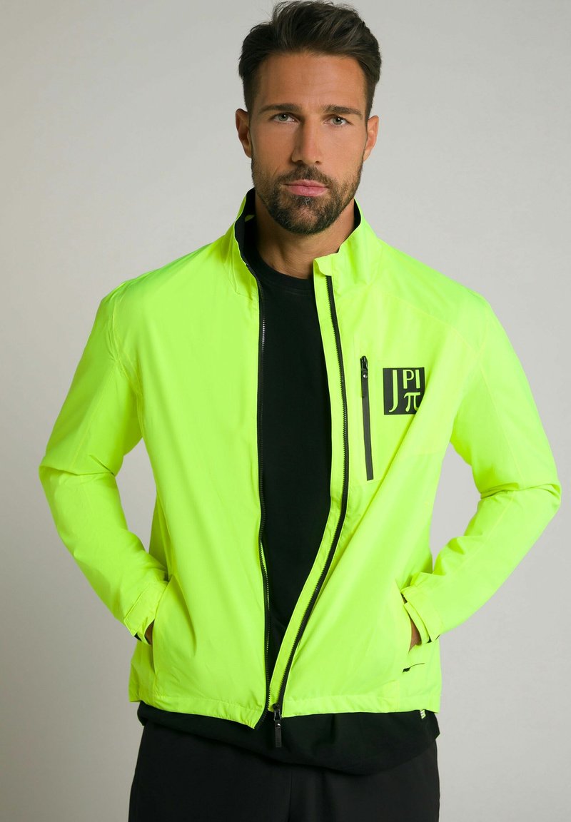 Helle neon-gelbe, leichte Jacke mit hohem Kragen, Reißverschluss vorne und schwarzen Akzenten, einschließlich einer Logotasche auf der Brust.