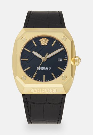 Kuldne oktagonaalne kell musta tekstuuriga sihvliga, Versace'i logo ja krooniga detail. Must nahkrihm nähtava õmblusega. Kuupäeva näitamine 3 ajal.