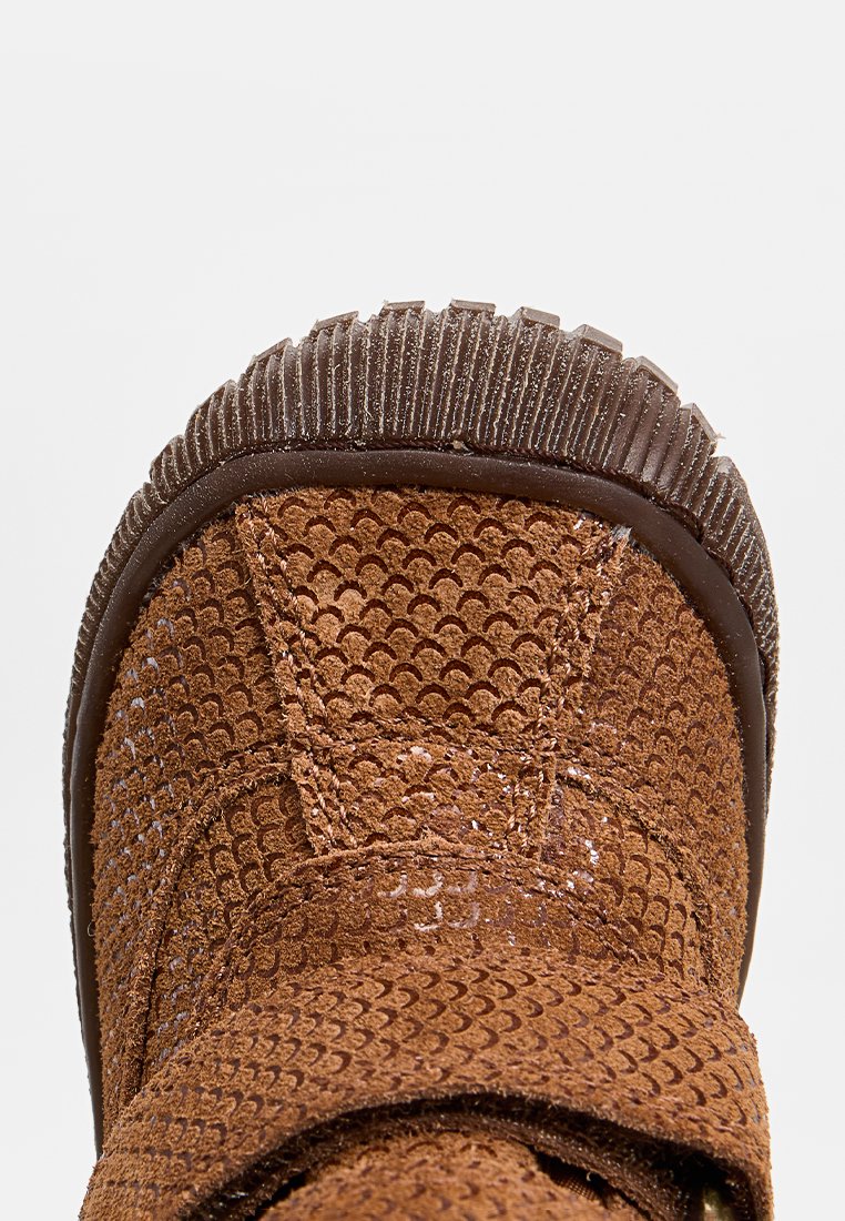 Braune Wildleder-Stiefelette mit strukturiertem Muster, Gummisohle und gepolstertem Kragen. Das Design umfasst einen breiten Riemen für einen sicheren Halt.