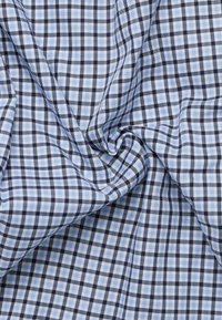 Tessuto a quadri blu e bianco con un motivo a griglia caratterizzato da linee navy scure. La texture sembra morbida e leggera.