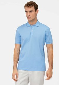 Polo shirt azzurro chiaro realizzato in tessuto liscio, con colletto, maniche corte e placca a tre bottoni. Design semplice senza motivi.