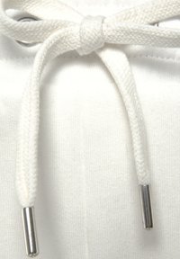 Weißes Baumwoll-Zugbänder mit einer geknoteten Schleife, aus strukturiertem Stoff und silbernen Spitzen. Wird durch eine Metallöse an einem Kleidungsstück gefädelt.